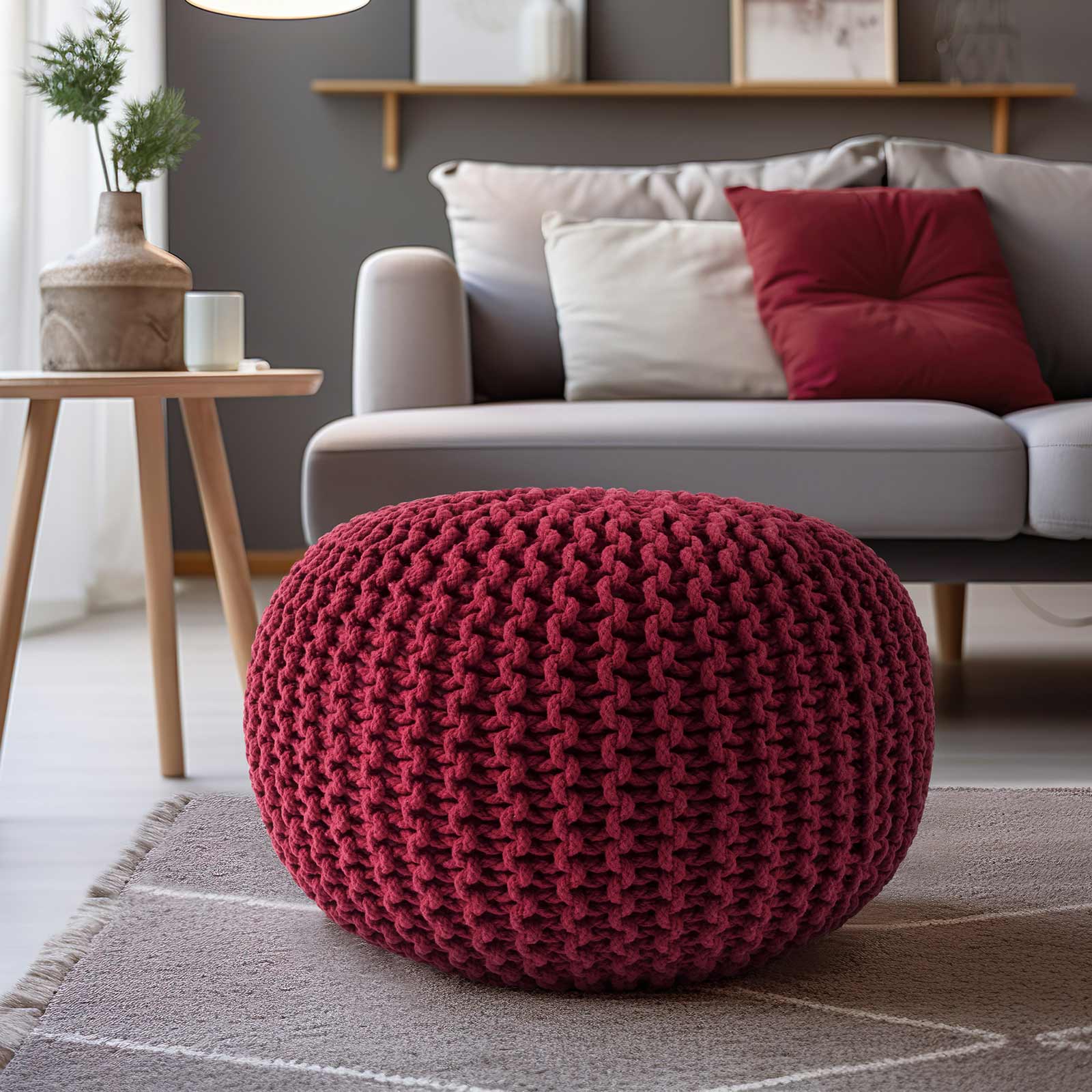 Puff tejido rojo utilizado como pieza de acento en una sala moderna con sofá gris, cojines a juego y alfombra de tonos neutros - Tufan.