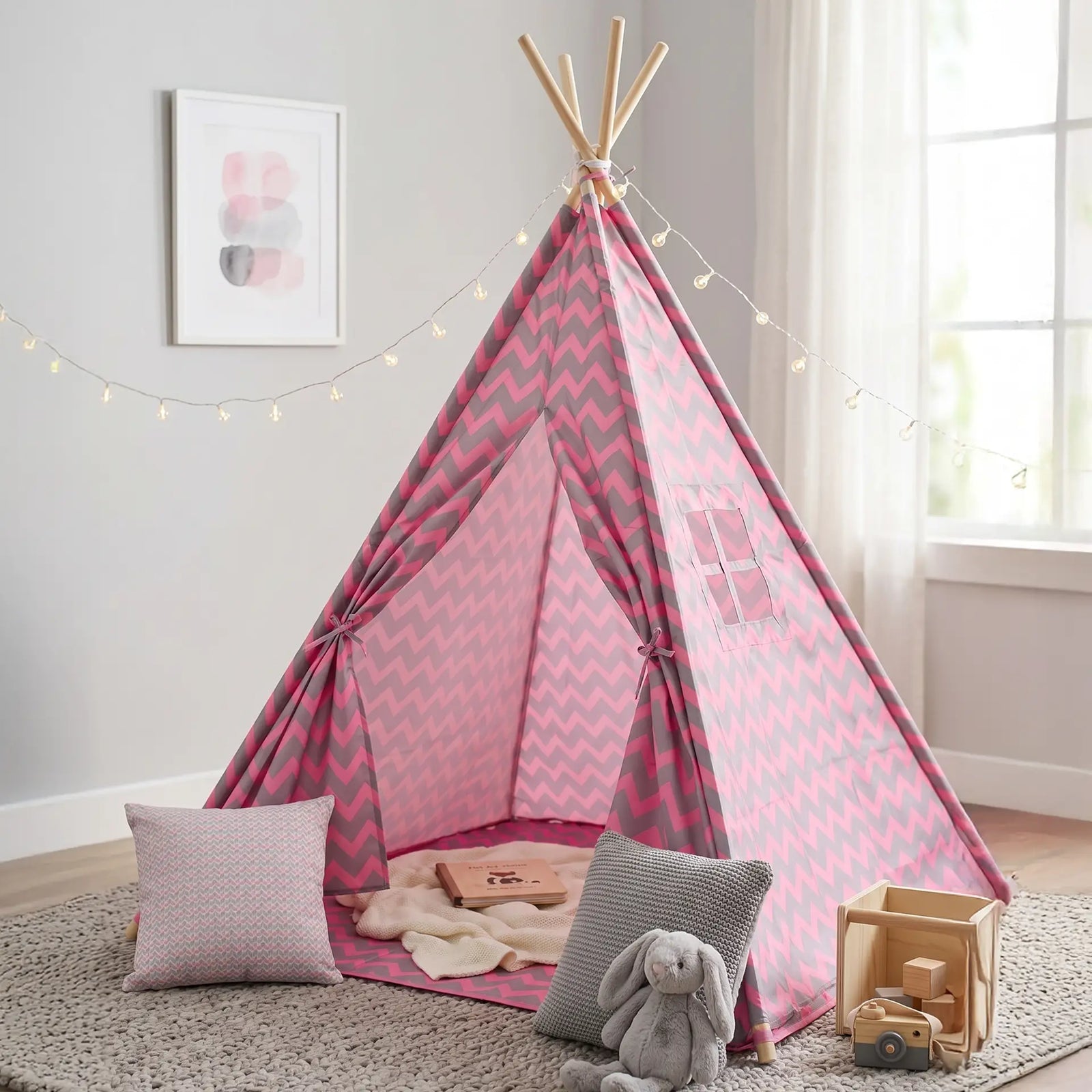 Habitación infantil decorada con tipi tienda rosa y gris, cojines decorativos, peluches y luces de guía en un ambiente acogedor - Tufan