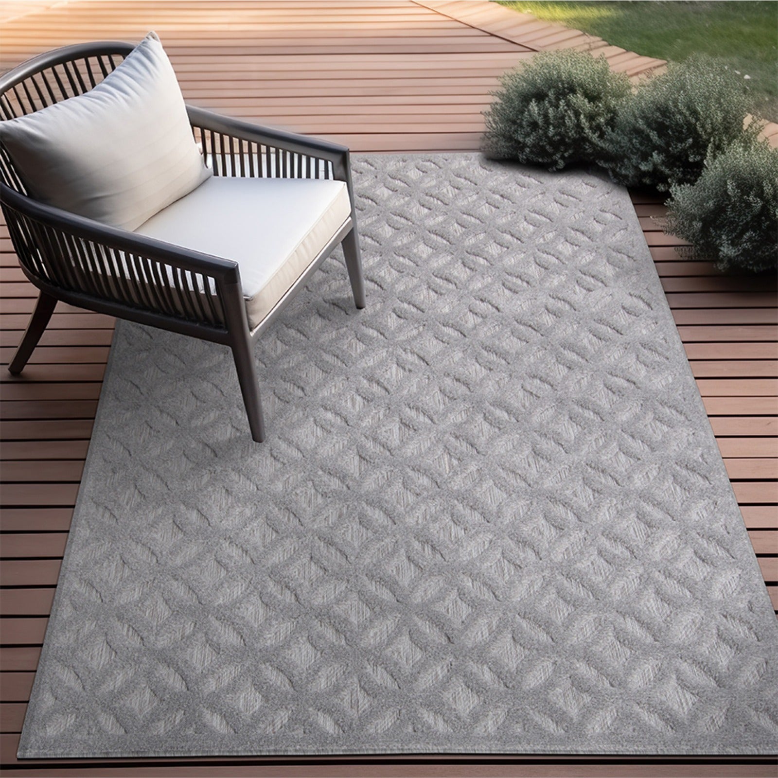 Tapete geométrico gris para exterior colocado en terraza de madera junto a silla
