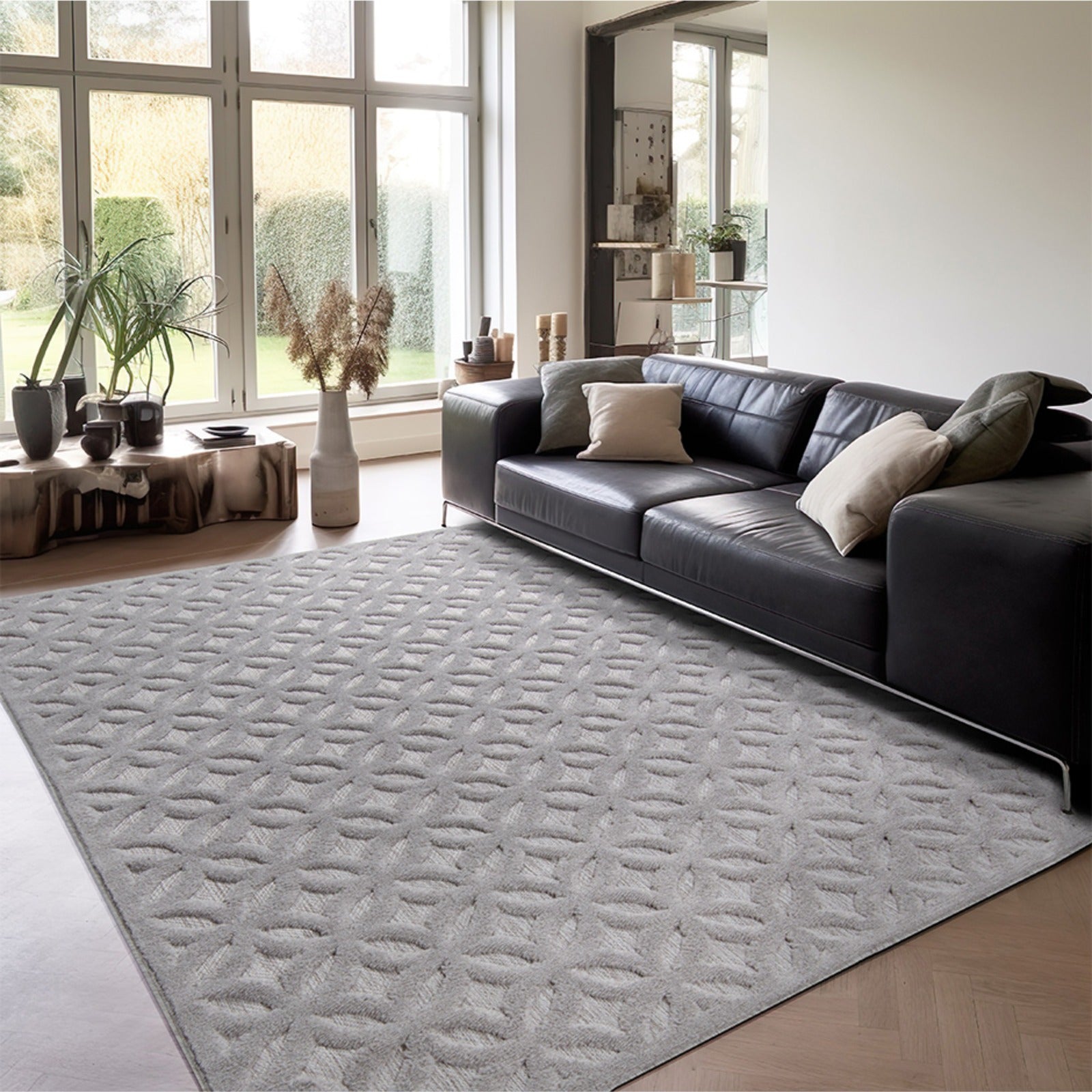 Tapete gris de diseño geométrico decorando sala moderna con ventanales y sillones oscuros