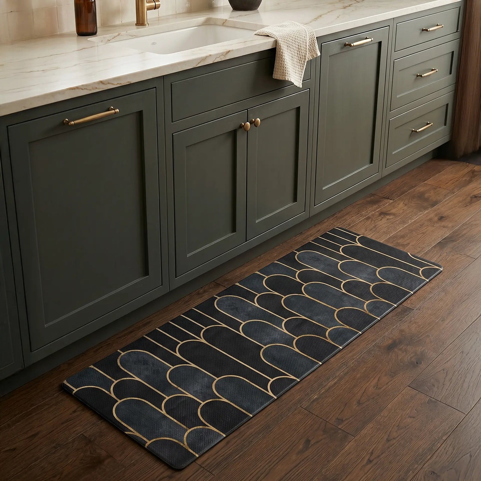 Cocina de lujo con gabinetes verdes y detalles dorados, complementada con un tapete antifatiga azul oscuro sobre piso de madera - Tufan.